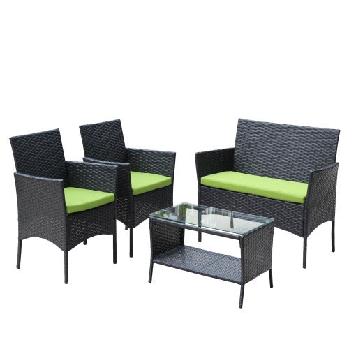 Four-piece black wicker patio set with green cushions and glass-top table