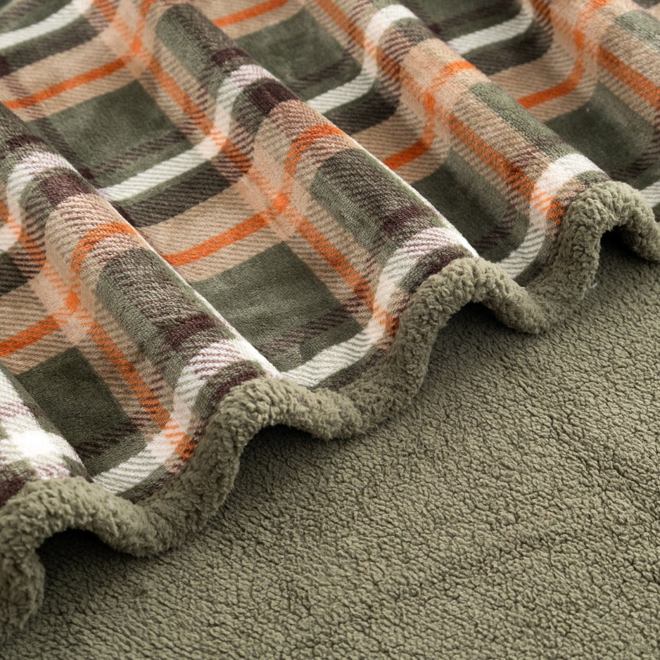 Close-up of green plaid throw blanket with sherpa reverse side